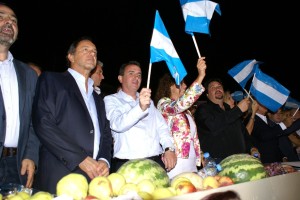 Momento patriotico, más de 40 mil personas elevan la bandera argentina. En el palco lo hacen Scioli, Pérez, Buzzi, De la Sota y Closs.