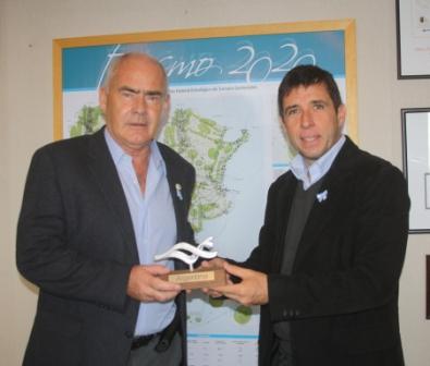 El Ministro de Turismo, Enrique Meyer junto al piloto Juan Manuel Silva, quien exhibe la distinción Marca País.